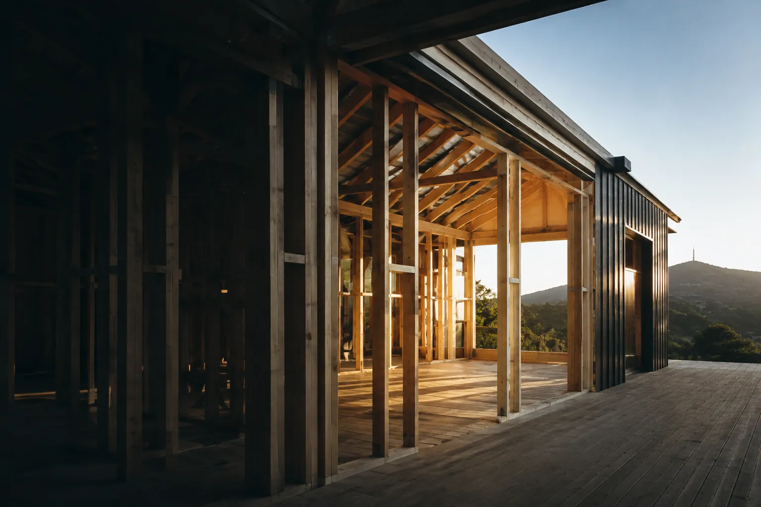 Timber framing and a charcoal-clad residential building in evening light