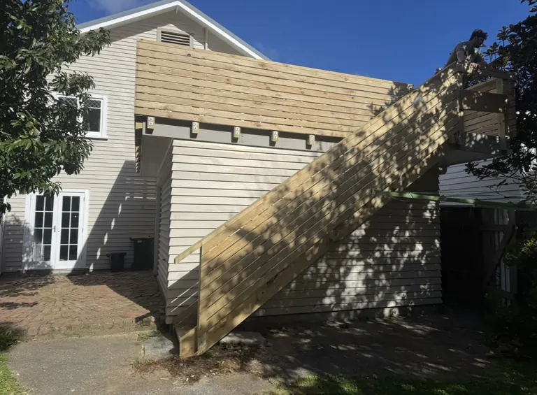 Exterior timber stairs and screening beside a house