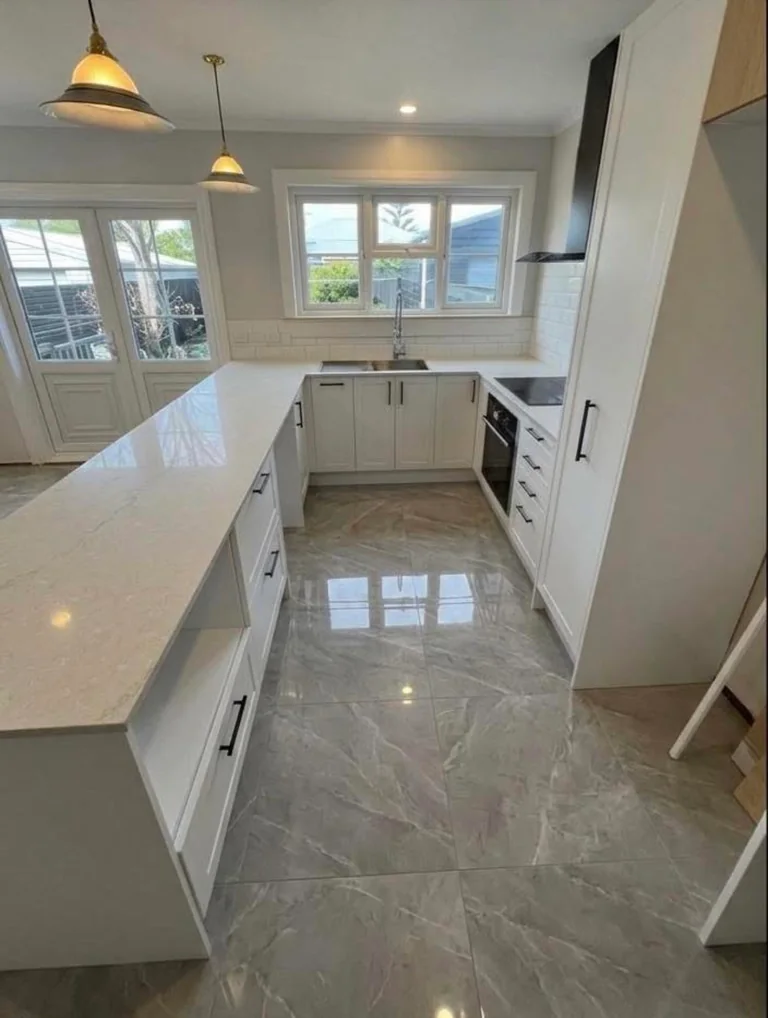 White kitchen cabinetry with tiled flooring and a bright window